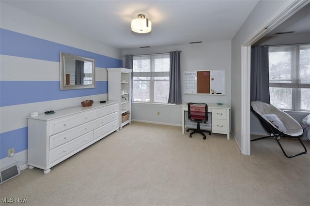 office area with visible vents, light carpet, and baseboards