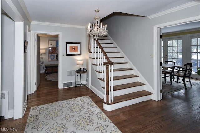 stairway featuring ornamental molding, a chandelier, baseboards, and wood finished floors