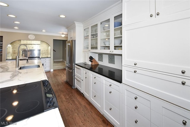 kitchen with dark wood finished floors, electric range, white cabinetry, a sink, and high end refrigerator