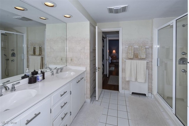 full bathroom featuring a stall shower, visible vents, a sink, and tile patterned floors