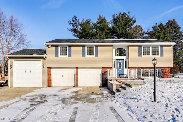 raised ranch featuring driveway and brick siding