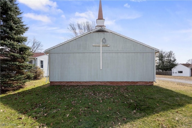 view of side of home with an outbuilding, a pole building, and a lawn