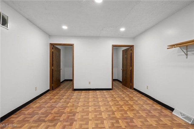 empty room featuring recessed lighting, visible vents, and baseboards