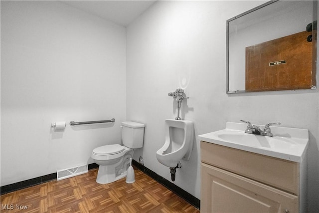 half bathroom with toilet, vanity, visible vents, and baseboards