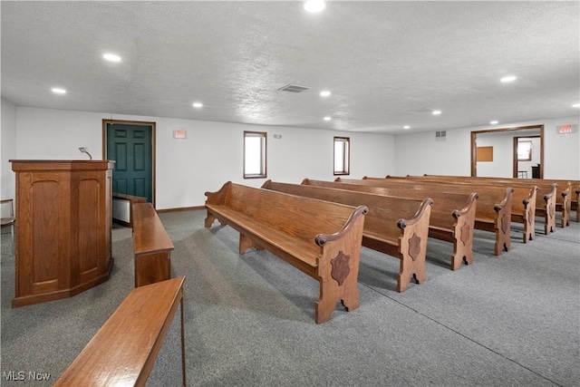 rec room with a textured ceiling, dark carpet, visible vents, and recessed lighting