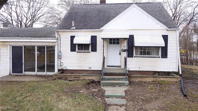 view of front of home with a shingled roof and a chimney