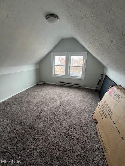 bonus room featuring a textured ceiling, lofted ceiling, a baseboard heating unit, carpet flooring, and baseboards