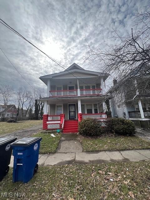 american foursquare style home with covered porch and a balcony