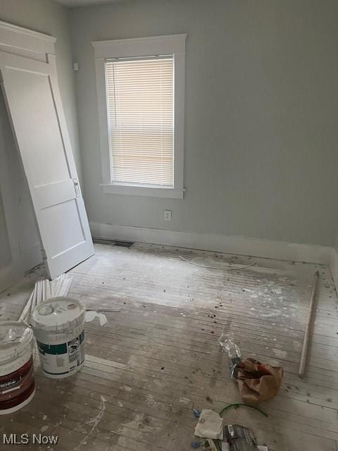 interior space featuring baseboards and hardwood / wood-style floors