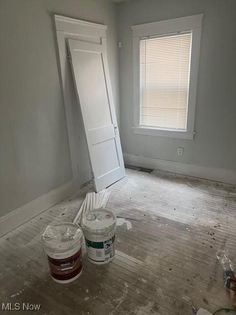 spare room featuring hardwood / wood-style floors and baseboards