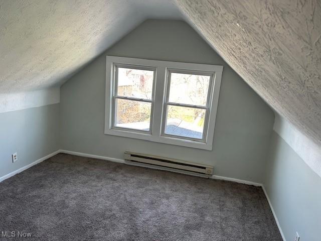 bonus room featuring a baseboard heating unit, baseboards, vaulted ceiling, and carpet floors