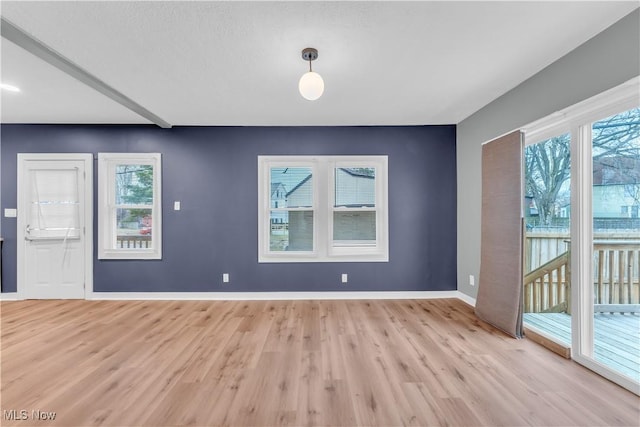 empty room with light wood-type flooring and baseboards