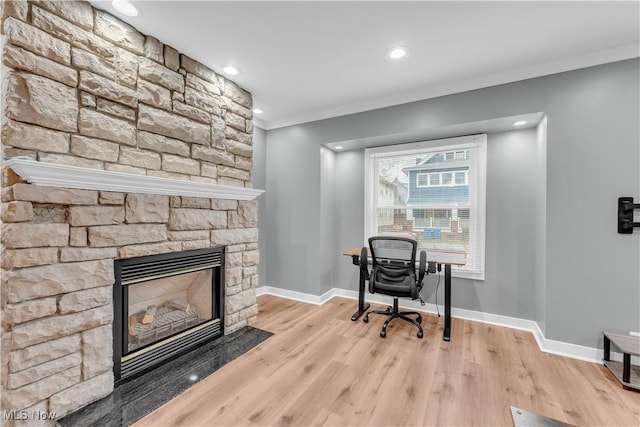 office featuring ornamental molding, a fireplace, wood finished floors, and baseboards