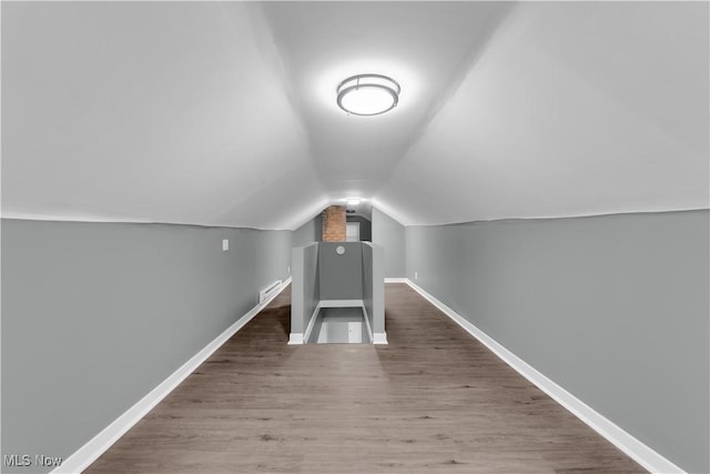 bonus room featuring vaulted ceiling, wood finished floors, visible vents, and baseboards