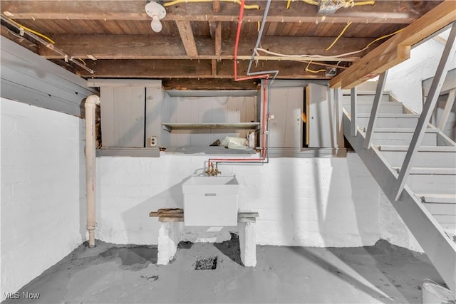 unfinished basement with stairway and a sink