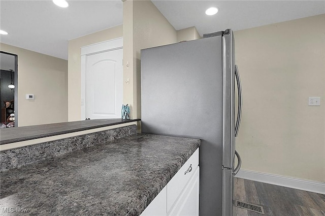 kitchen with dark wood-style flooring, dark countertops, freestanding refrigerator, and recessed lighting