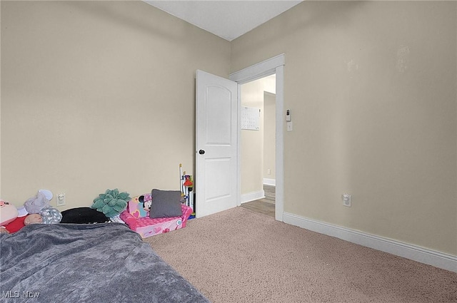 bedroom with carpet floors and baseboards