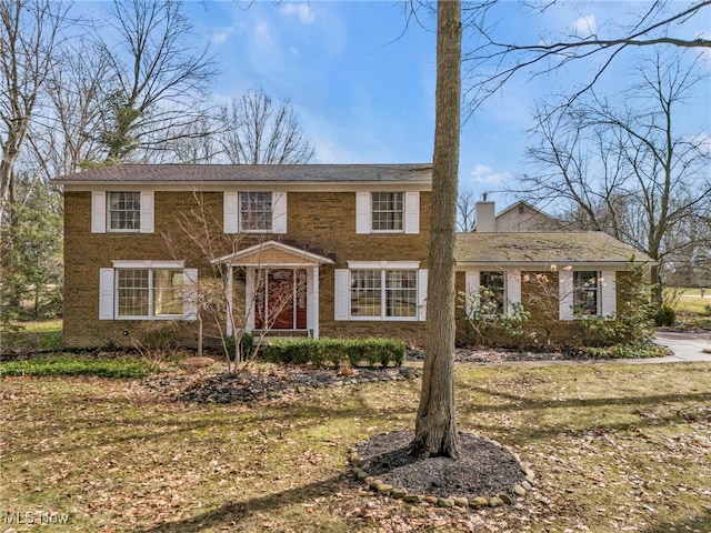 view of front of home featuring brick siding and a chimney