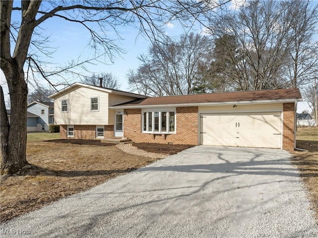 tri-level home with driveway, brick siding, and an attached garage