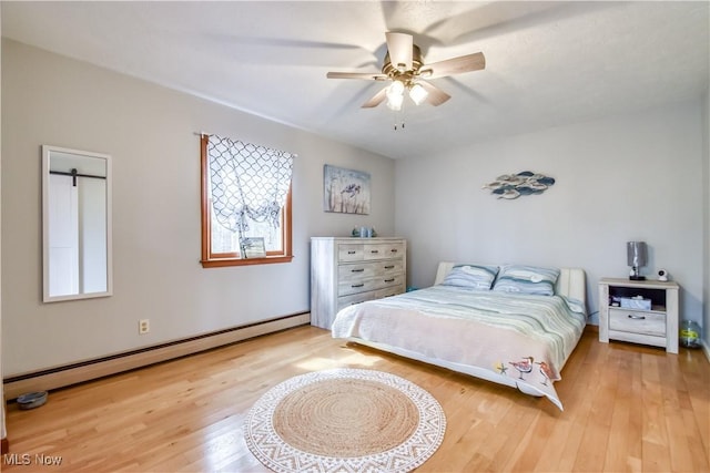 bedroom with a baseboard radiator, ceiling fan, and wood finished floors