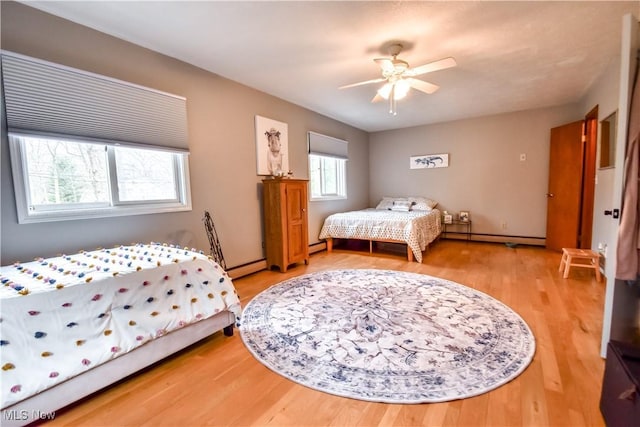 bedroom featuring a baseboard heating unit, baseboard heating, and wood finished floors