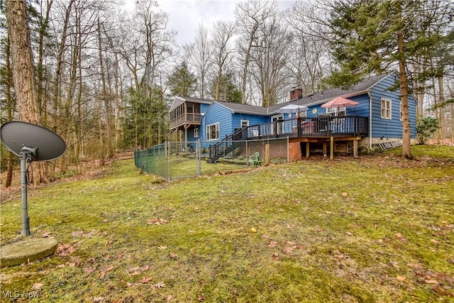 rear view of property featuring stairs, a yard, a wooden deck, and fence