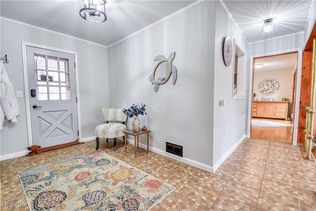 foyer entrance with ornamental molding, visible vents, baseboards, and an inviting chandelier