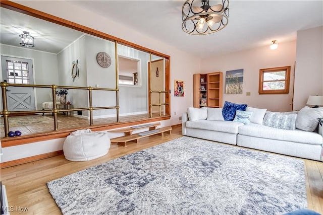 living room with crown molding, baseboards, and wood finished floors