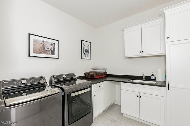 laundry area with washing machine and dryer, a sink, and cabinet space