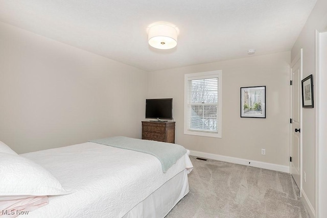 bedroom with light carpet, visible vents, and baseboards