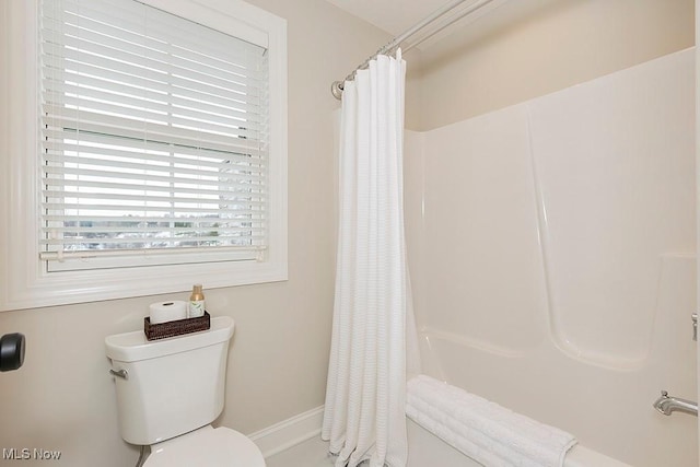 bathroom featuring curtained shower and toilet