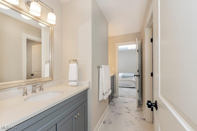 bathroom with marble finish floor, baseboards, and vanity