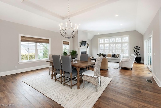 dining area with baseboards, a fireplace, visible vents, and dark wood-type flooring