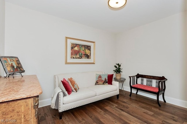 sitting room with baseboards and wood finished floors