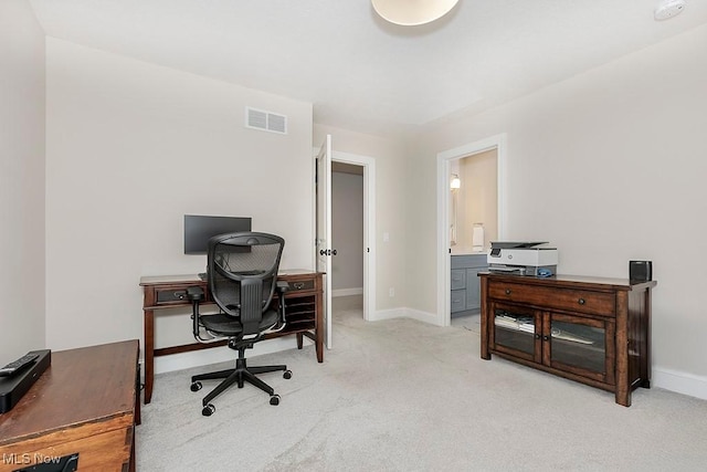 office featuring visible vents, light carpet, and baseboards