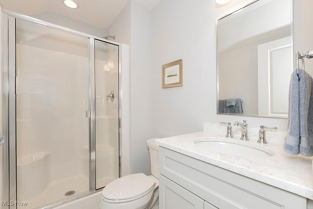 bathroom with a stall shower, vanity, and toilet