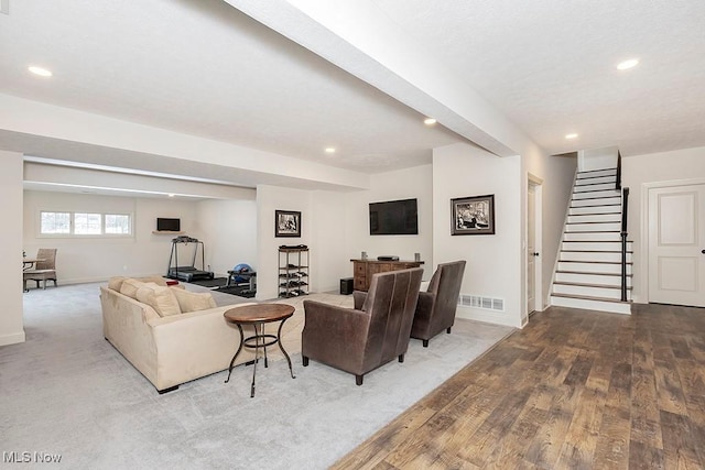 living area featuring recessed lighting, wood finished floors, visible vents, baseboards, and stairway