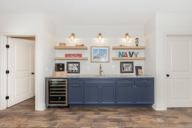 bar featuring beverage cooler, baseboards, indoor wet bar, dark wood-type flooring, and a sink