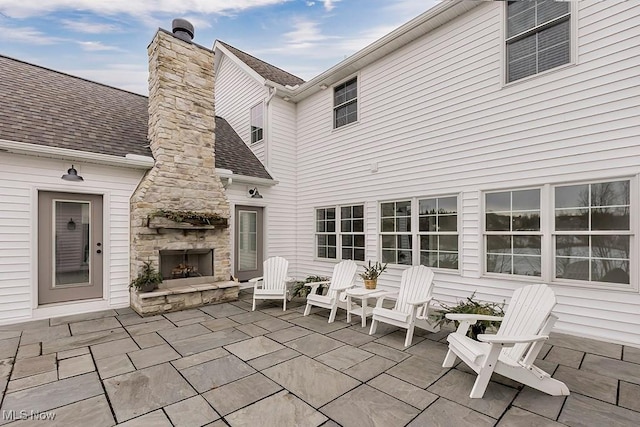 view of patio / terrace featuring an outdoor stone fireplace