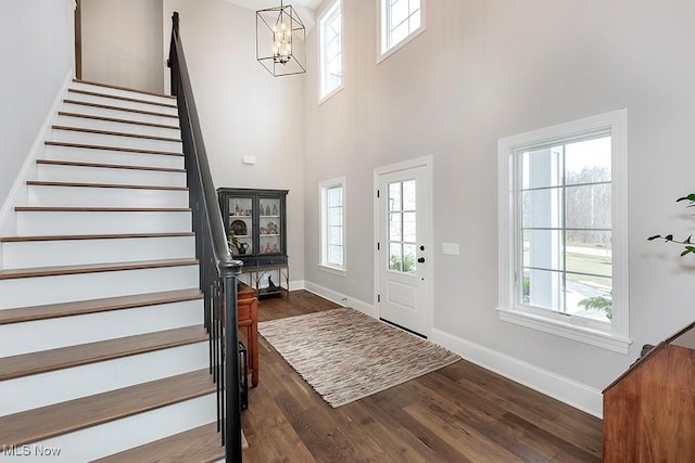 foyer with a high ceiling, stairway, dark wood finished floors, and baseboards