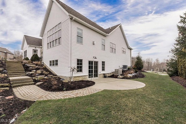 rear view of house featuring a yard, a shingled roof, a patio, and cooling unit