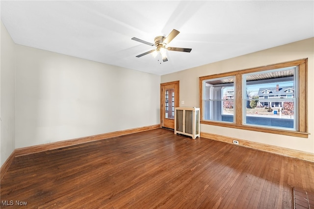 unfurnished room featuring ceiling fan, baseboards, and hardwood / wood-style flooring