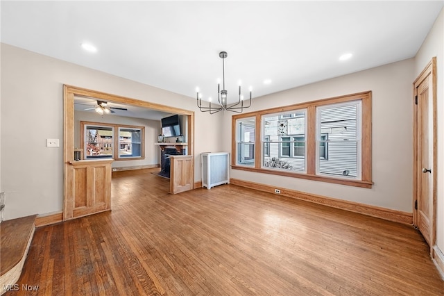 kitchen featuring radiator heating unit, a fireplace, wood finished floors, and baseboards