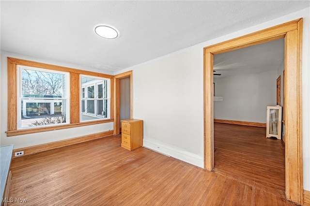 unfurnished room featuring baseboards and wood finished floors