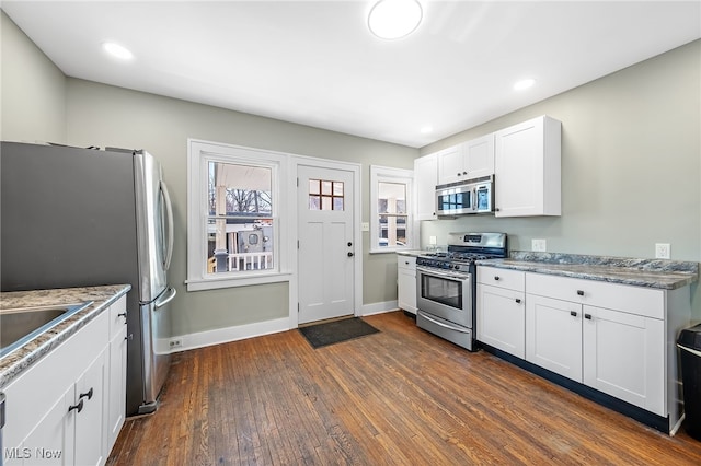 kitchen with baseboards, white cabinets, appliances with stainless steel finishes, dark wood-type flooring, and recessed lighting