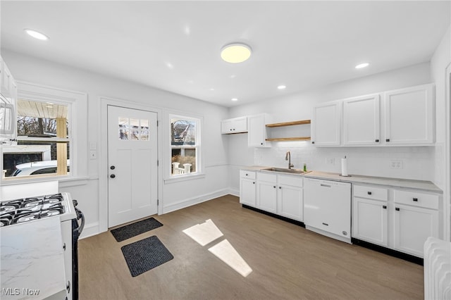 kitchen with a healthy amount of sunlight, white appliances, white cabinets, and a sink