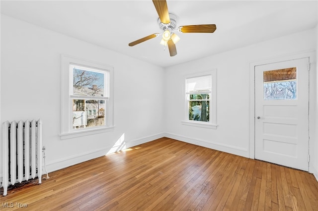 entrance foyer featuring a ceiling fan, light wood-type flooring, radiator, and baseboards