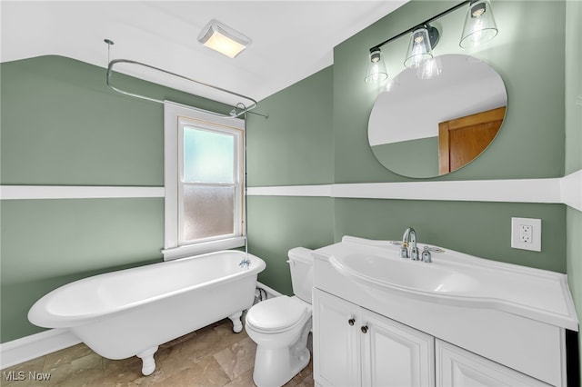 bathroom with toilet, a freestanding tub, and vanity