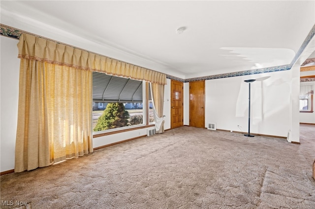 carpeted empty room featuring visible vents and baseboards