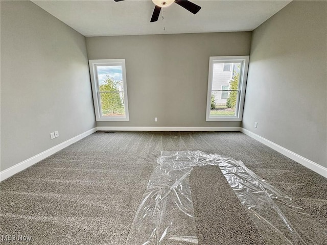 unfurnished room with baseboards, carpet, and a healthy amount of sunlight